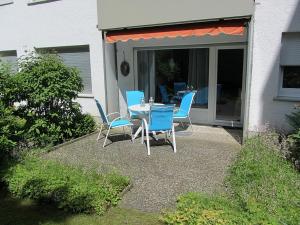 eine Terrasse mit blauen Stühlen und einem Tisch auf der Veranda in der Unterkunft Domizil Strandallee 30 Domizil Strandallee 30 Appartement 01 in Timmendorfer Strand