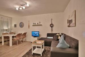 ein Wohnzimmer mit einem Sofa und einem Tisch in der Unterkunft Domizil Strandallee 30 Domizil Strandallee 30 Appartement 01 in Timmendorfer Strand