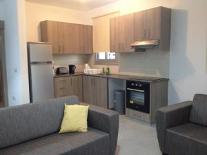 a kitchen with two chairs and a couch in a kitchen at Niro Apartments in Polis Chrysochous