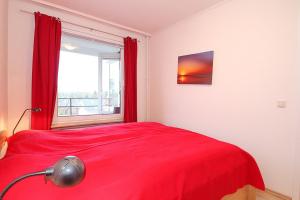 ein rotes Bett in einem Zimmer mit Fenster in der Unterkunft Carpe Diem Carpe Diem Appartement 161 in Niendorf