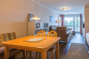 - une salle à manger et un salon avec une table et des chaises dans l'établissement Residenz am Hang Residenz am Hang Appartement 411, à Scharbeutz