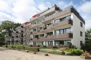 un grand immeuble d'appartements avec balcon et fleurs dans l'établissement Residenz am Hang Residenz am Hang Appartement 411, à Scharbeutz