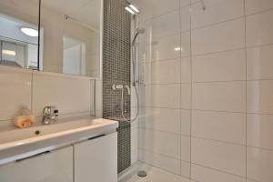 Un baño blanco con ducha y lavabo. en Haus Miramar Treffert Appartement 38, en Niendorf 23 fotos más