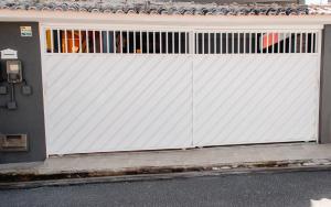 a white gate on the side of a house at Moni & Junior Hospedagem in Angra dos Reis