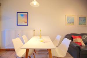 une salle à manger avec une table blanche et des chaises blanches dans l'établissement Residenz Ostseestrand Residenz Ostseestrand Appartement 30, à Scharbeutz