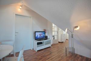 sala de estar con TV y mesa de comedor en Haus am Ahornweg 6 Haus am Ahornweg 6 Appartement 8, en Scharbeutz