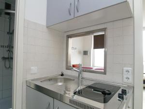 una cucina con lavandino e specchio di Seetempel Seetempel Appartement 42 a Scharbeutz