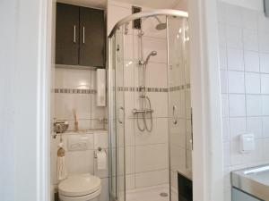 La salle de bains est pourvue d'une douche en verre et de toilettes. dans l'établissement Seetempel Seetempel Appartement 42, à Scharbeutz