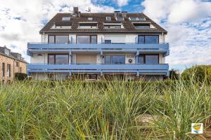 una grande casa blu seduta in cima a un campo di Seetempel Seetempel Appartement 42 a Scharbeutz