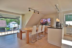 cocina y comedor con mesa de madera y sillas en Haus am Seehof Seemöwe Appartement 4 en Sierksdorf
