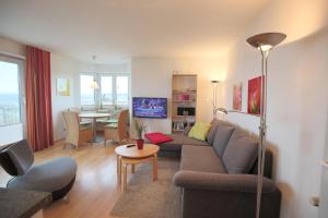 ein Wohnzimmer mit einem Sofa und einem Tisch in der Unterkunft Strandschlößchen Strandschlösschen Appartement 9 in Haffkrug