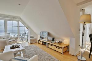 een woonkamer met witte meubels en een groot raam bij Stranddomizil Stranddomizil Appartement 13 in Haffkrug
