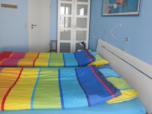 a bed with a colorful striped comforter in a room at Residenz Ostseestrand Appartement 23 in Scharbeutz +24 photos