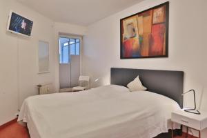 une chambre avec un lit blanc et un tableau au mur dans l'établissement Residenz Ostseestrand Appartement 10, à Scharbeutz 28 autres photos