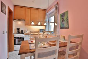 uma cozinha com uma mesa de jantar em madeira e cadeiras em Strandperle Strandperle Appartement 201 em Haffkrug