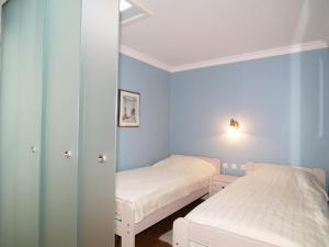 2 Betten in einem Zimmer mit blauen Wänden in der Unterkunft Haus Waldburg Haus Waldburg in Scharbeutz