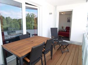 uma sala de jantar com uma mesa de madeira e cadeiras em Strandglück Haus B Strandglück Appartement 12B em Scharbeutz
