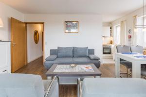 un soggiorno con divano e tavolo di Ostseeblick Ostseeblick Appartement 13 a Scharbeutz