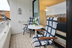 einen kleinen Balkon mit 2 Stühlen und einem Tisch in der Unterkunft Hanseat am Hang 3 - 5 Hanseat Appartement 21 in Scharbeutz