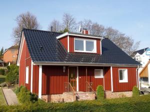 une maison rouge avec un toit noir dans l'établissement Ferienhaus LUV & LEE Ferienhaus LUV und LEE, à Scharbeutz