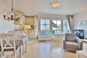 uma cozinha e sala de estar com mesa e cadeiras em Ostseeblick Ostseeblick Appartement 6 em Scharbeutz