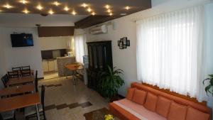 a living room with an orange couch and a kitchen at Sobe BCRNJAC in Međugorje