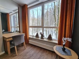 Cette chambre dispose d'un bureau et d'une fenêtre avec des arbres. dans l'établissement Apartament 10 Resort Kozubnik Kiczora SPA - 5D Apartments, à Porąbka