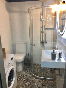 a bathroom with a shower and a sink and a washing machine at Nikoletta's Home 2 in Komotini +25 photos