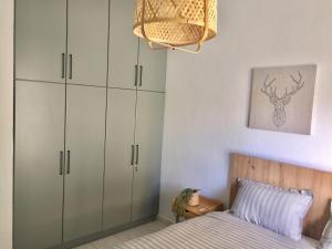 a bedroom with a bed with white cabinets and a chandelier at Nikoletta's Home 2 in Komotini