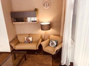una sala de estar con 2 sillas y una lámpara. en Veselyj Zajets en Pirnove