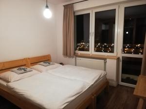 a bedroom with a bed and a window with lights at Willa u Kuruca in Witów