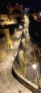 una calle de la ciudad con luces de la calle por la noche en Appartamenti Belvedere, en Cortona