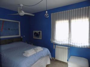 a blue bedroom with a bed with towels on it at Bungalow CASIOPEA Internet 300 Mb SAT SMARTTV in El Campello