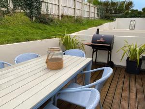 a table with chairs and a laptop on a patio at Ohana House in Newquay