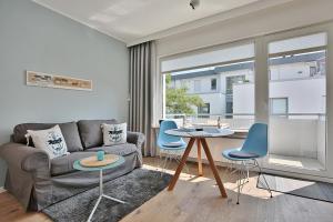 sala de estar con sofá, mesa y sillas en Haus Strandallee 188 Schmuckkästchen, en Timmendorfer Strand