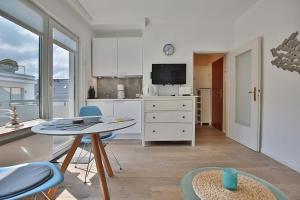 a kitchen with a table and chairs and a tv at Haus Strandallee 188 Schmuckkästchen in Timmendorfer Strand