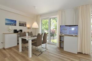 ein Esszimmer mit einem Tisch und einem TV in der Unterkunft Villa Stern Villa Stern Appartement 06 in Timmendorfer Strand