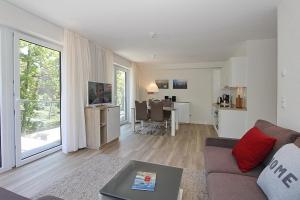 ein Wohnzimmer mit einem Sofa und einem Esszimmer in der Unterkunft Villa Stern Villa Stern Appartement 09 in Timmendorfer Strand
