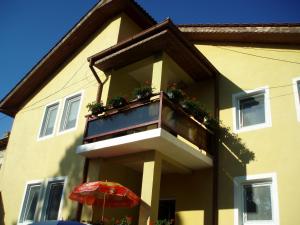 un edificio con un balcón con una sombrilla roja en Pension Edelweiss, en Eforie Sud