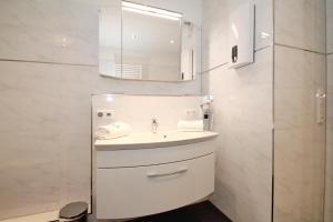 un bagno bianco con lavandino e specchio di Residenz am Timmendorfer Platz Residenz am Timmendorfer Platz Appartement 2 a Timmendorfer Strand
