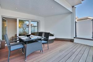 una sala da pranzo con tavolo, sedie e divano di Residenz am Timmendorfer Platz Residenz am Timmendorfer Platz Appartement 2 a Timmendorfer Strand Altre 10 foto