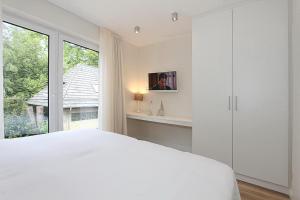 - une chambre avec un lit blanc et une fenêtre dans l'établissement Villa Stern Villa Stern Appartement 08, à Timmendorfer Strand