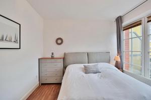 ein Schlafzimmer mit einem Bett, einer Kommode und einem Fenster in der Unterkunft Haus Parkblick, Timmendorfer Strand Haus Parkblick Appartement 07 in Timmendorfer Strand