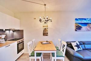 eine Küche und ein Esszimmer mit einem Tisch und einem Sofa in der Unterkunft Haus am Höppnerweg 5 Haus am Höppnerweg 5 Appartement 09 in Timmendorfer Strand