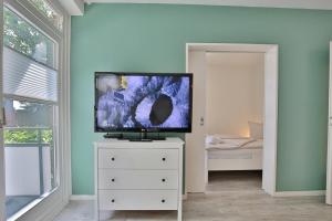 einen Flachbild-TV auf einer Kommode in einem Zimmer in der Unterkunft Haus am Höppnerweg 5 Haus am Höppnerweg 5 Appartement 09 in Timmendorfer Strand