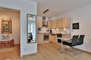 a kitchen and dining room with a table and chairs at Haus Strandstrasse Strandstrasse 150 Appartement 3 in Niendorf