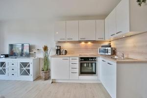 a white kitchen with white cabinets and a sink at Am Elchgrund, im Brook 9 Am Elchgrund Im Brook 9 Appartement 08 in Timmendorfer Strand