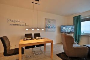 a living room with a dining room table and chairs at Haus Seebrücke Haus Seebrücke Appartement 08 in Niendorf