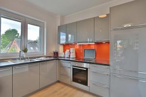 eine Küche mit Geräten aus Edelstahl und einem Fenster in der Unterkunft Haus Bergstrasse 4 Haus Bergstraße 4 Appartement 9 in Timmendorfer Strand