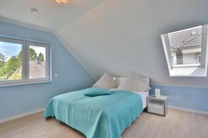 ein Schlafzimmer mit einem Bett und zwei Fenstern in der Unterkunft Haus Bergstrasse 4 Haus Bergstraße 4 Appartement 9 in Timmendorfer Strand